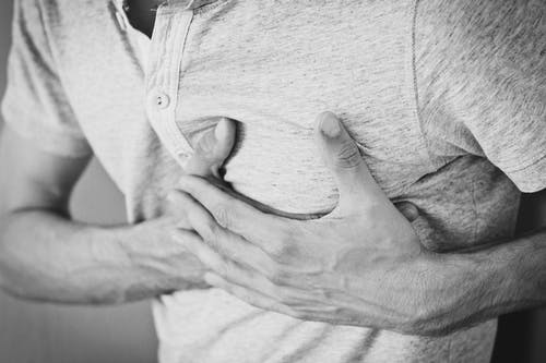 Heartburn, white man clutching chest. Black and white picture.