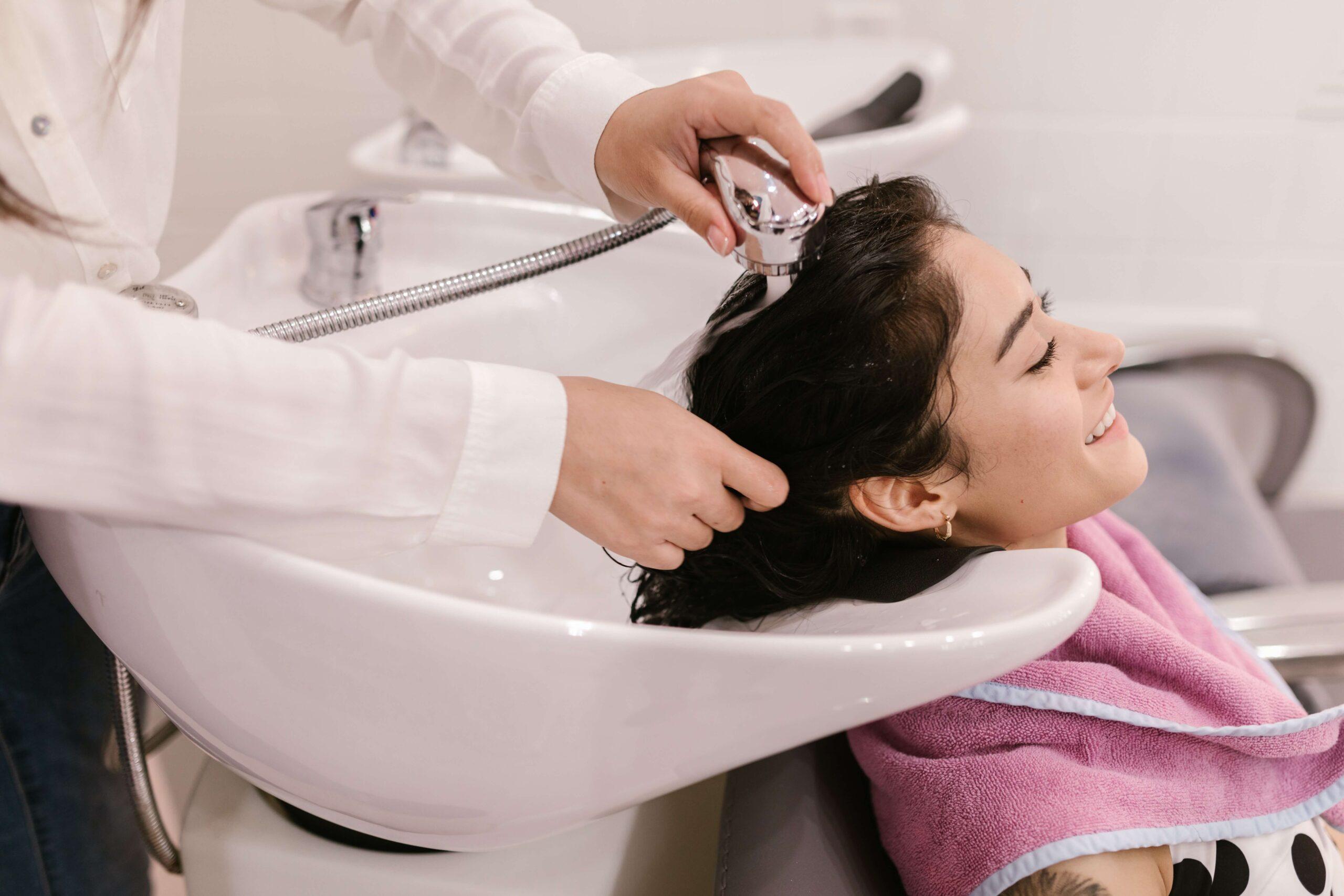 Woman getting hair washed at a salon due to excessive dandruff from Seborrheic Dermatitis. Is Seborrheic Dermatitis associated with Celiac Disease