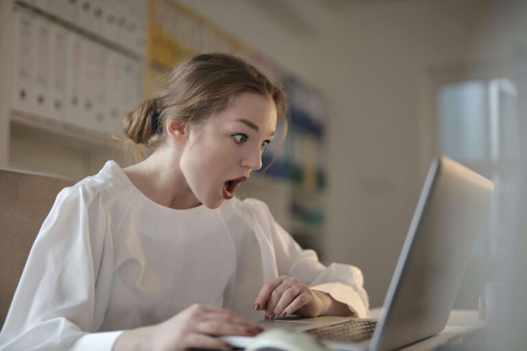 Young white woman looking at computer screen looking shocked with mouth opened. What does gut health affect?