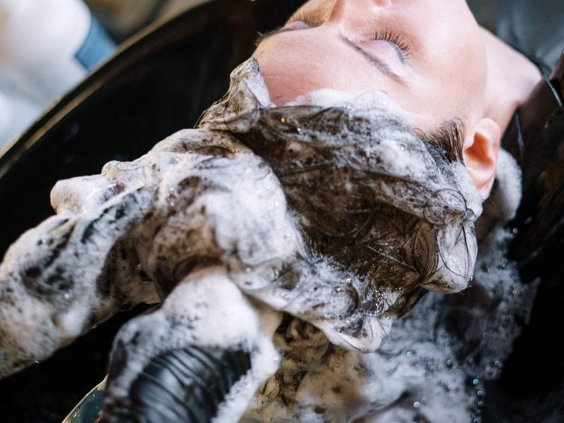 White woman getting her hair washed at a hair salon. Using dandruff shampoo. Bad Dandruff